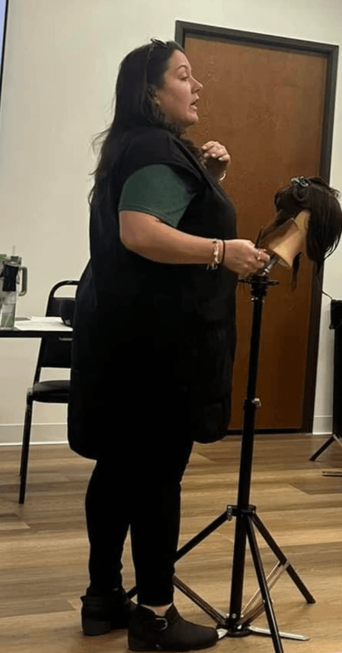 Manager teaching on a mannequin head during stylist development